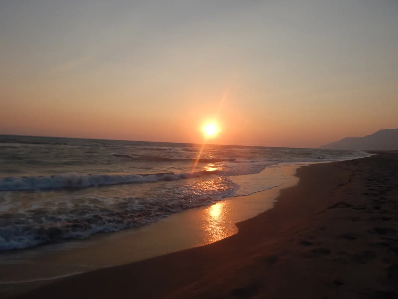 Gelemiş köyü üzerinde gün batımı, tepeler ve gökyüzünün turuncu renkleri