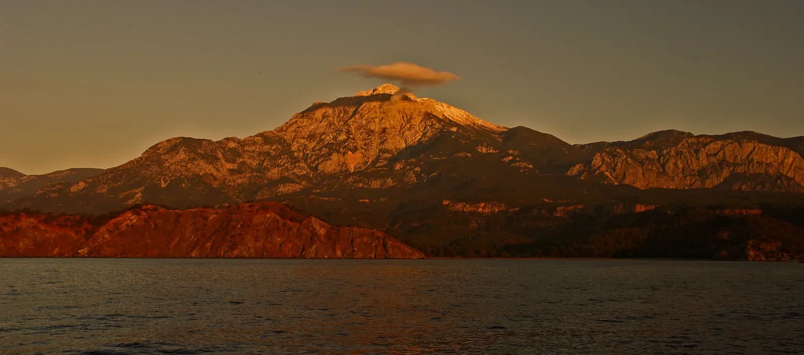 Sabah ışığında kızıla bürünmüş Tahtalı Dağı ve önündeki deniz