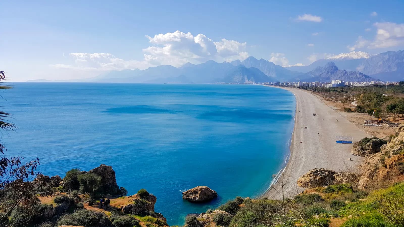 Falezlerin üzerinden Konyaaltı plajı, Antalya kıyısı ve arkada Beydağları